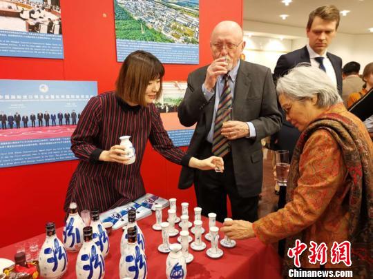 中德兩國(guó)來(lái)賓在招待會(huì)上品嘗中國(guó)汾酒?！＄娦?攝
